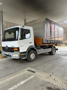 Nákladné vozidlo Mercedes Atego so špeciálnou nadstavbou pre prepravu kontajnerov a ťažkých nákladov, využívané pri preprave materiálu pre zemné a výkopové práce. Ideálne pre zabezpečenie dopravy strojov a zariadení potrebných na výkopové práce a úpravy terénu v rámci ponuky služieb spoločnosti po-bagrujem.sk