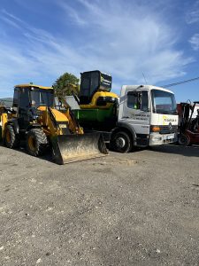 Traktorbager JCB 3CX Compact a bager CAT pripravené na prácu vedľa nákladného vozidla Mercedes Atego spoločnosti po-bagrujem.sk. Stroje využívané pre výkopové práce, zemné práce a prepravu stavebných materiálov, vhodné pre rôzne stavebné projekty a úpravy terénu.